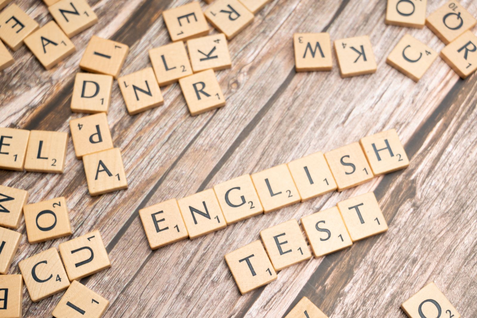 Lettres de Scrabble formant les mots English test sur une table en bois